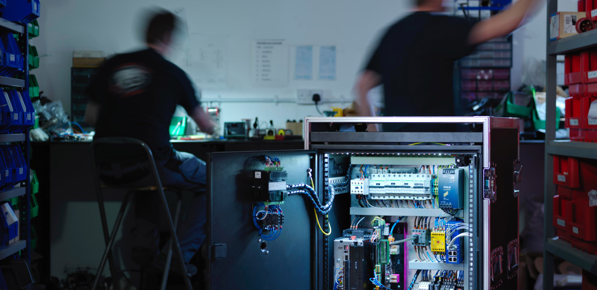 Men working behind electronics